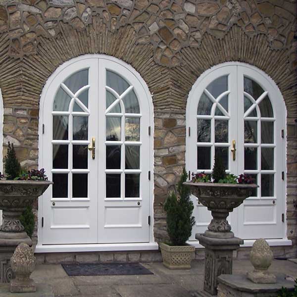 Two timber french doors which arched top