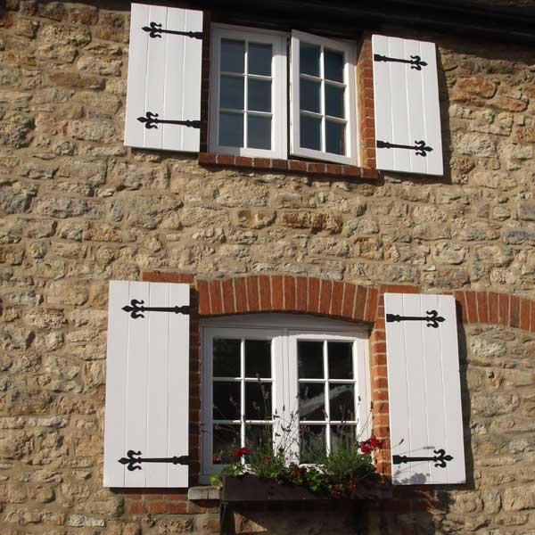 Traditional wooden windows with shutters installed on a cottage